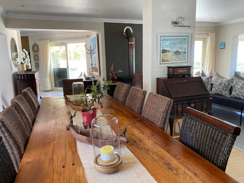Open-plan dining area with wooden table and woven chairs overlooking lounge