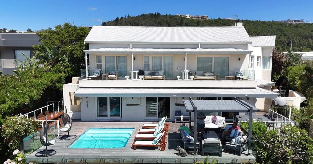 Modern white villa with pool, deck, and mountain views in Plettenberg Bay