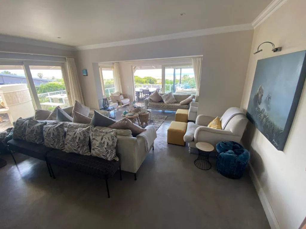 Spacious open-plan lounge with multiple seating areas and large windows