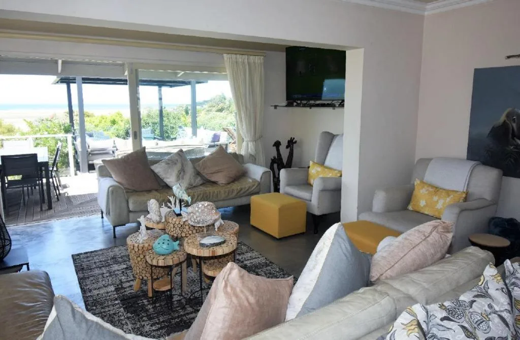 Spacious lounge with gray sofas, ocean view through glass doors