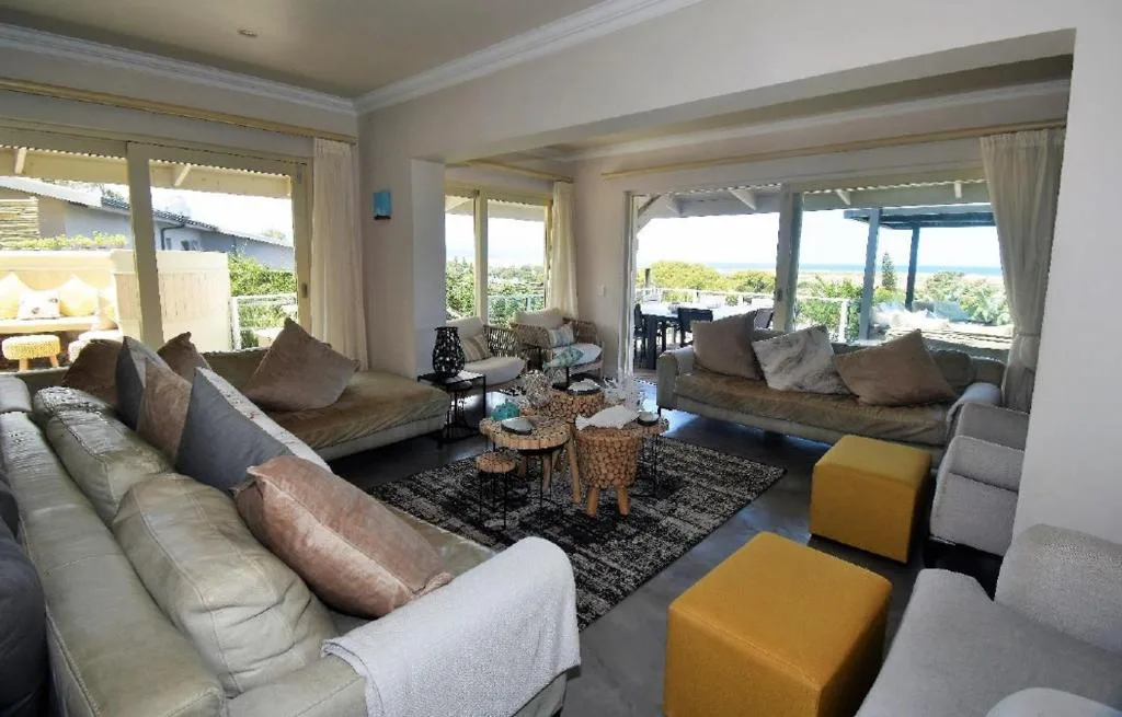 Spacious lounge with multiple sofas, large windows overlooking lagoon views
