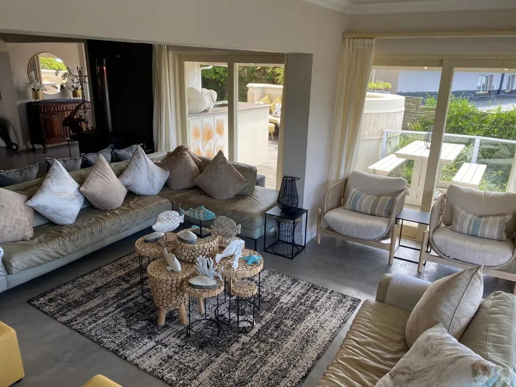 Spacious living room with comfortable seating overlooking coastal views through large windows