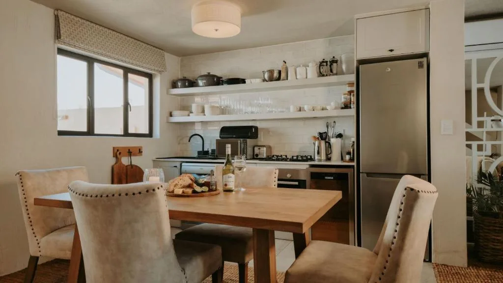 Open-plan kitchen with dining table, gas stove, and stainless steel appliances