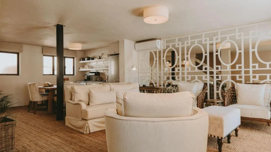 Spacious lounge with cream upholstered seating and geometric wall panels