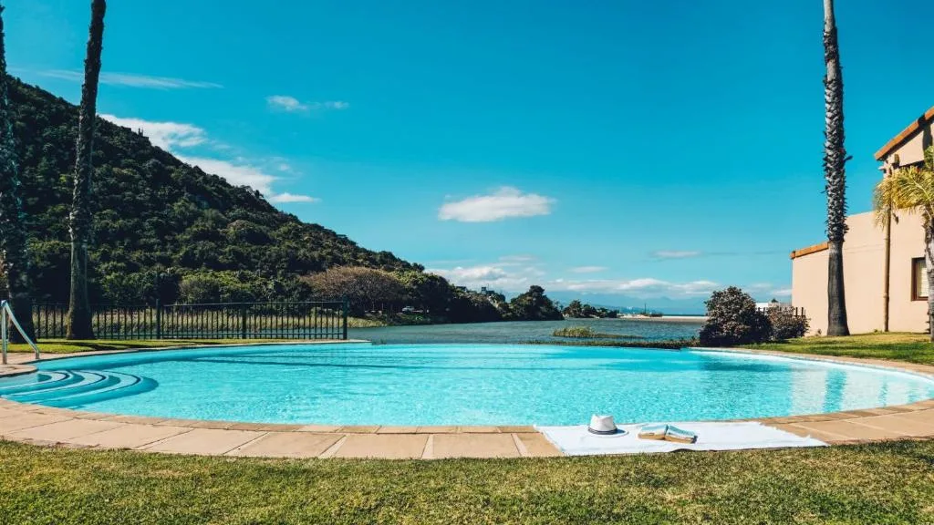 Sparkling turquoise swimming pool with lagoon and mountain views beyond