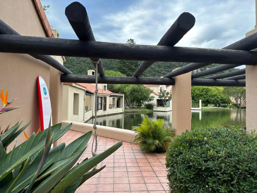 Wooden pergola deck with water views and lush garden landscaping