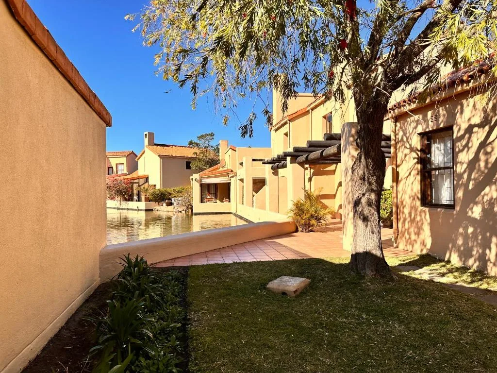 Warm terracotta buildings with manicured garden courtyard and mature tree