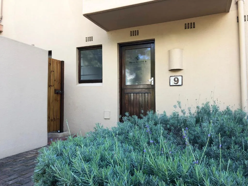 Cream-colored building entrance with dark wooden door and number nine