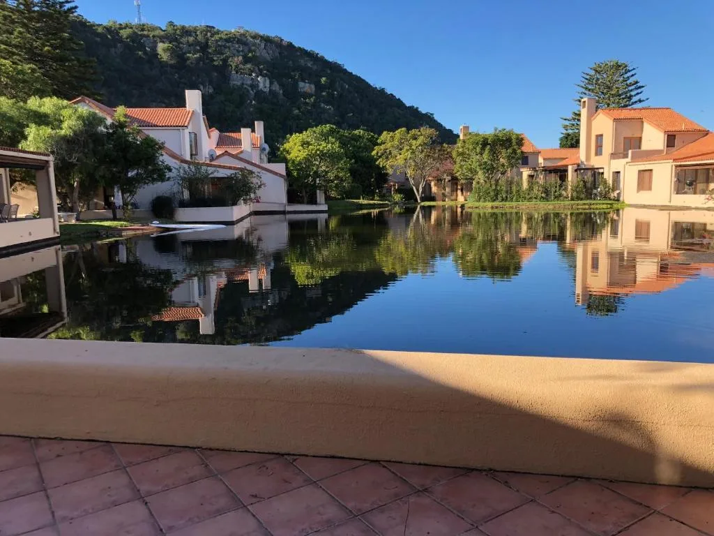 Serene lagoon view with colorful waterfront houses and mountain backdrop