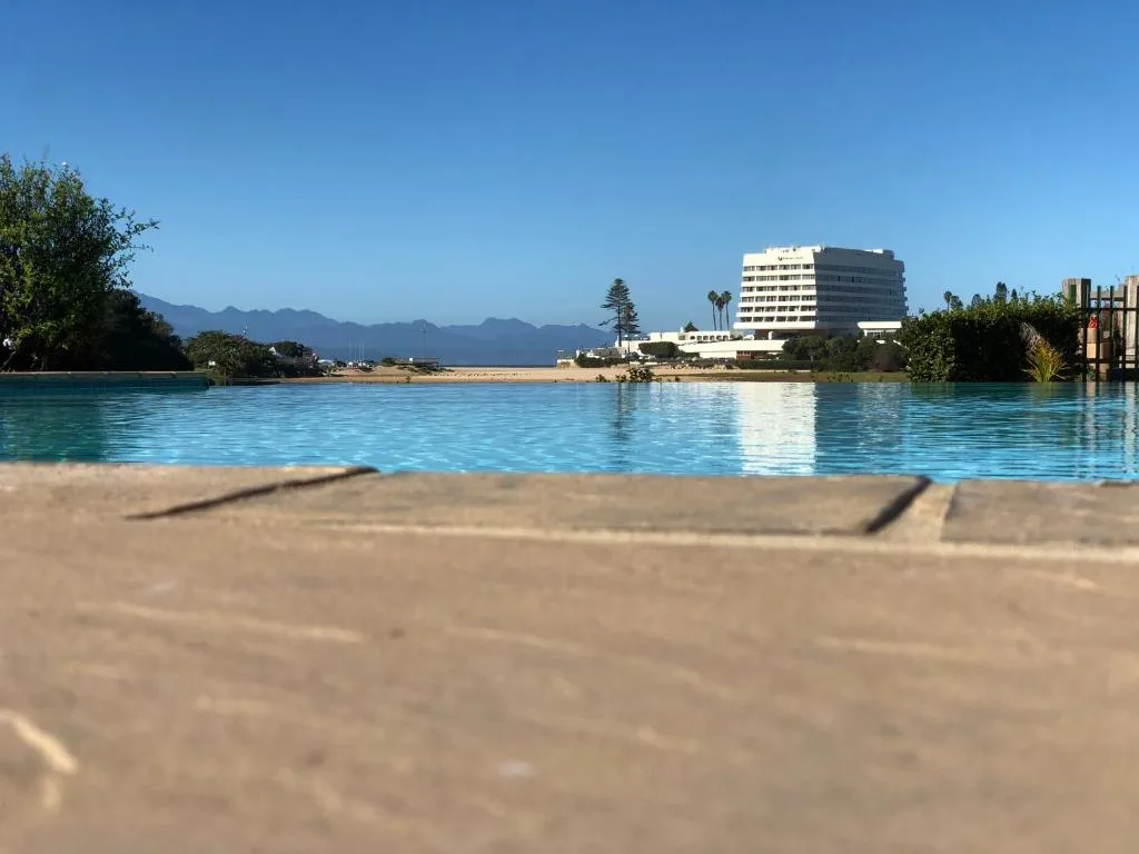 Turquoise lagoon waters with sandy beach and mountain backdrop