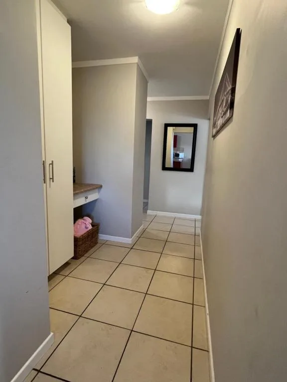 Clean hallway with tiled flooring and storage nook in apartment