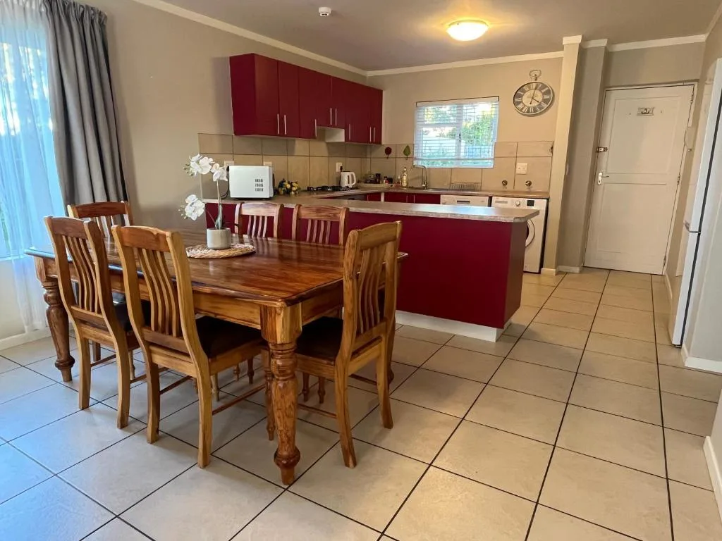 Wooden dining table with chairs in open-plan kitchen and dining area