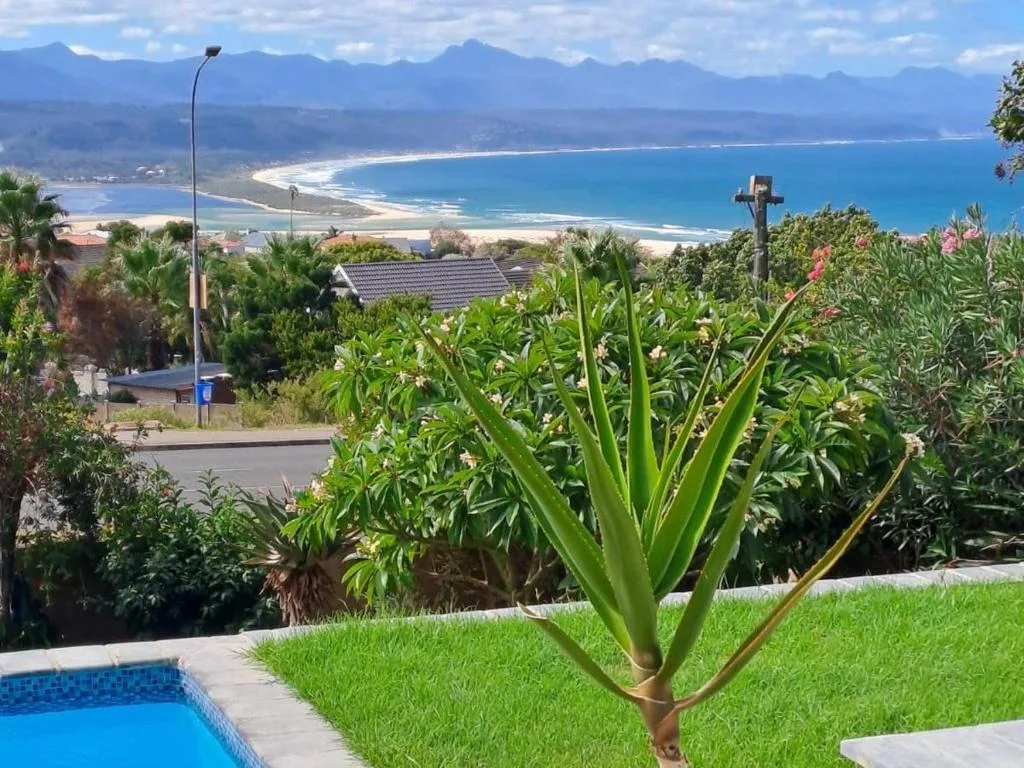 Panoramic coastal view with beach, mountains, and ocean from property gardens
