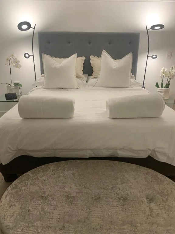 Modern bedroom with upholstered headboard, white linens, and decorative pillows