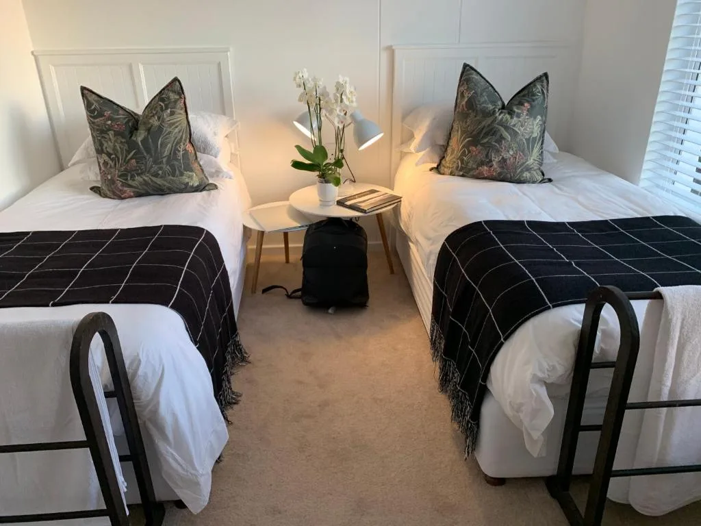 Twin bedroom with decorative pillows, white bedding, and tasteful decor