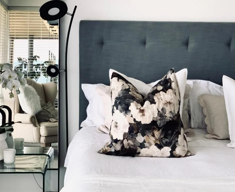 Modern bedroom with upholstered headboard, white bedding, and decorative pillows
