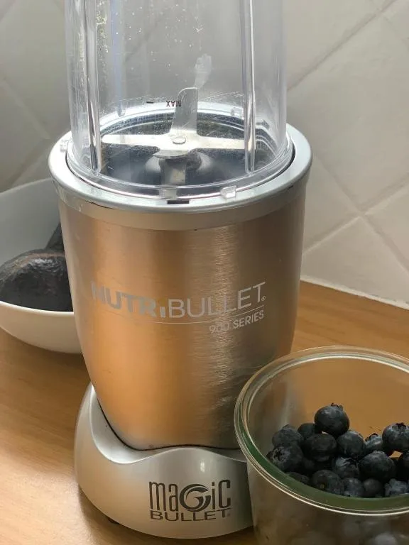 NutriBullet blender with fresh blueberries on wooden countertop