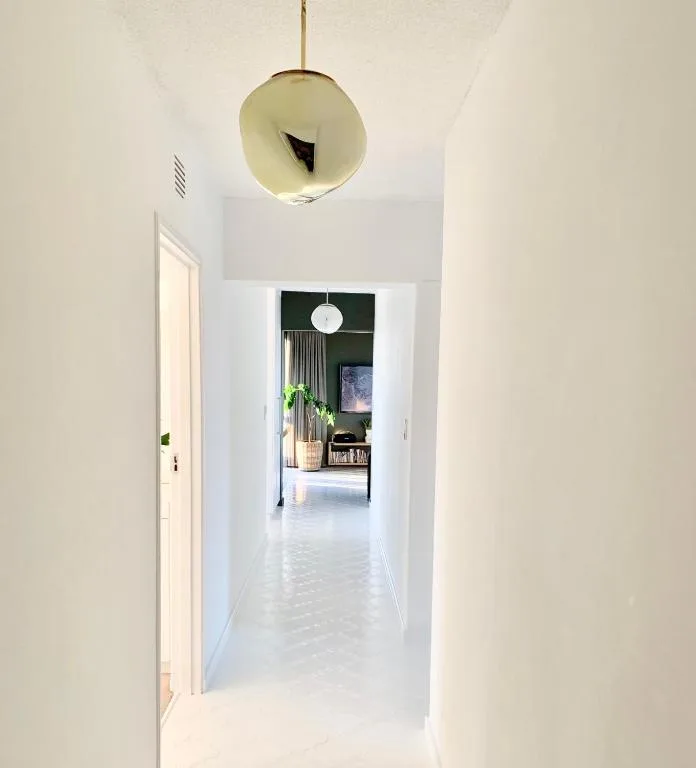 Bright hallway with pendant light fixture and modern interior design