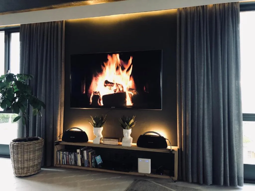Modern lounge with fireplace display, TV, and ambient lighting setup