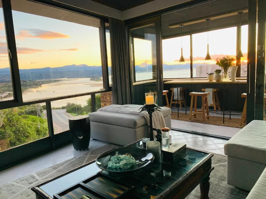 Panoramic sunset view of lagoon and mountains from modern apartment lounge