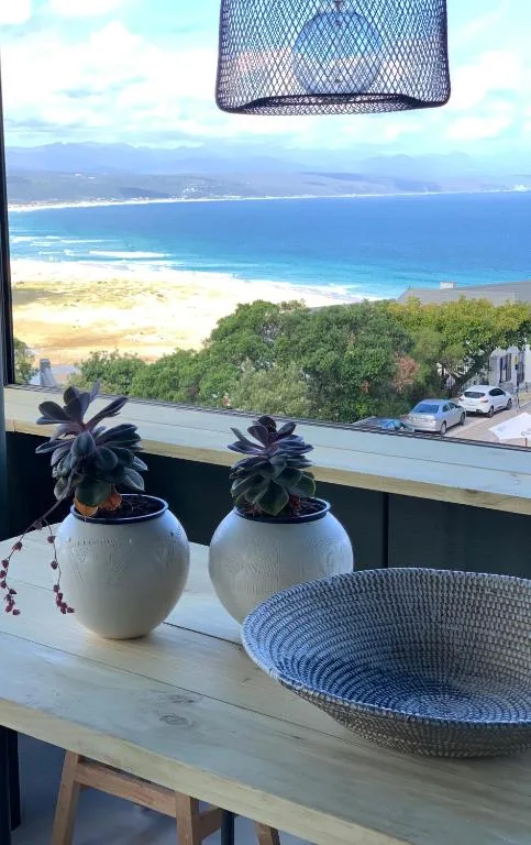 Panoramic coastal view from deck overlooking pristine beach and mountains