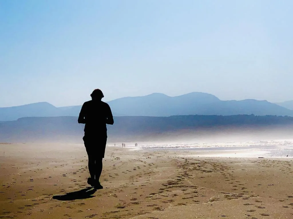 Scenic beach vista with mountains and morning mist in distance