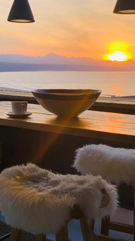 Stunning sunset over lagoon with mountains, viewed from deck seating area