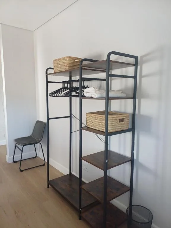 Lofted bed with storage shelves and woven baskets in bright room