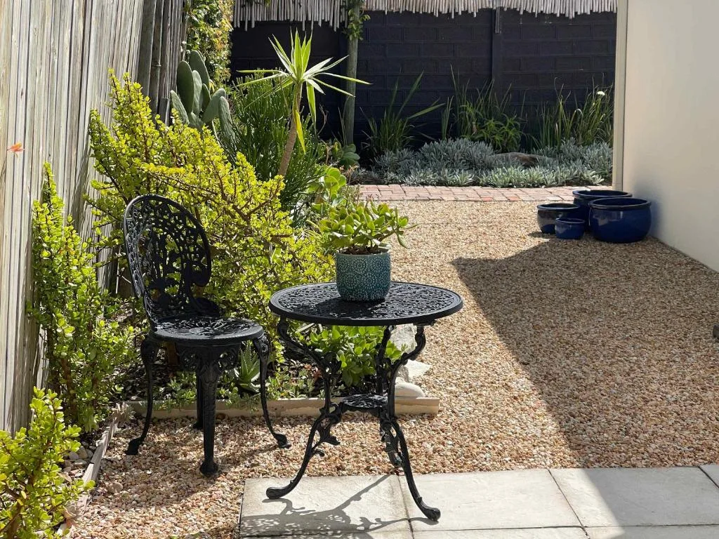 Courtyard seating area with decorative black tables and lush garden landscaping