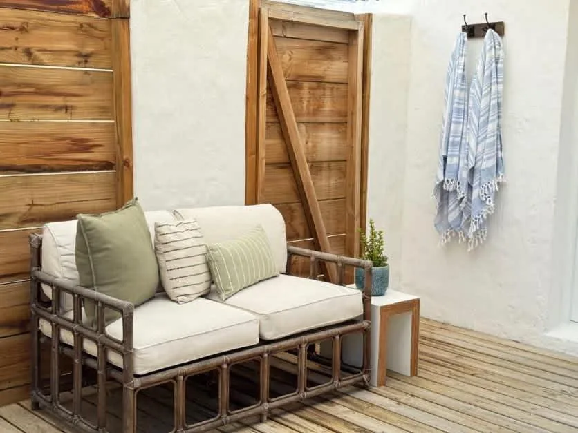 Wooden seating area with cushioned bench and potted plant outdoors
