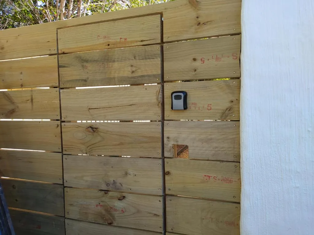 Wooden gate entrance with security device and metal hinges
