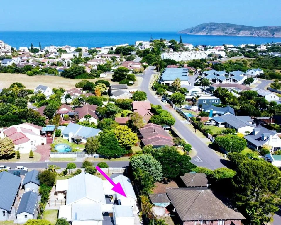 Aerial view of Plettenberg Bay suburb with ocean and mountains visible