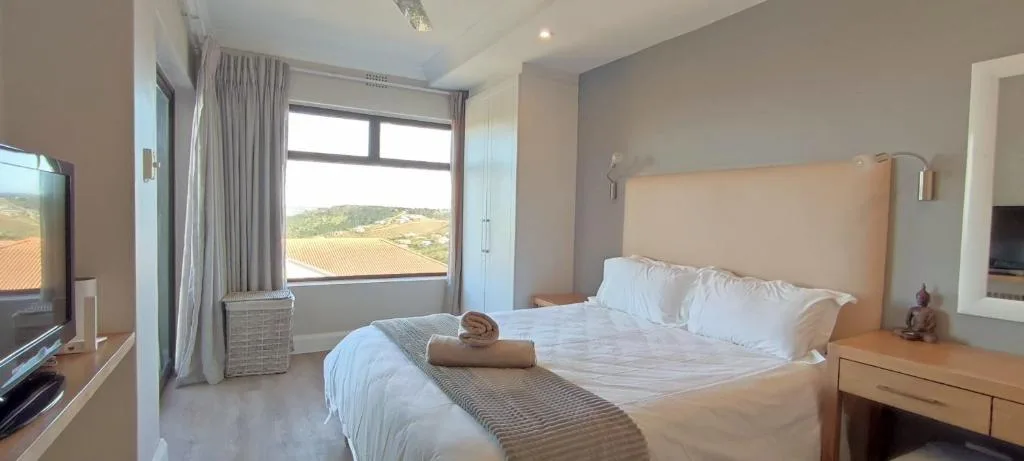 Bright bedroom with queen bed, large window overlooking vineyards and hills