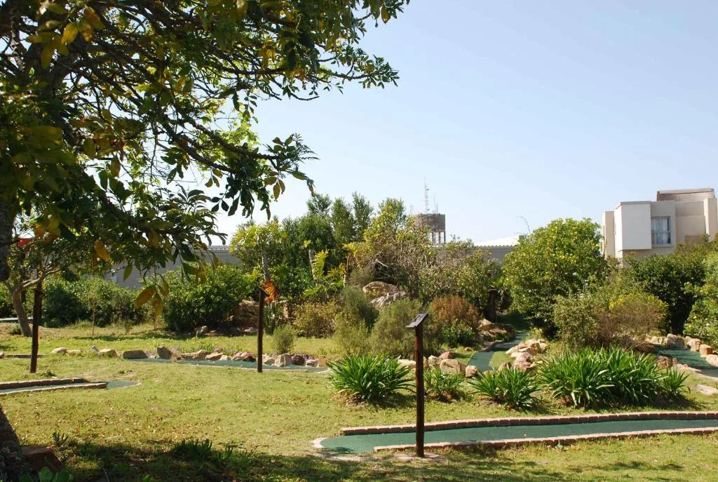 Garden grounds with mature trees, mini golf course, and residential buildings beyond