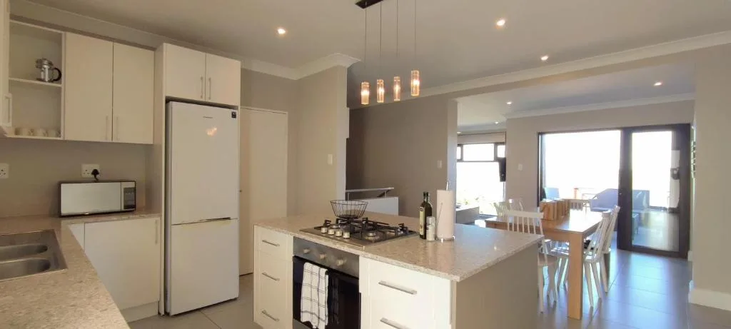 Modern kitchen with white cabinetry, gas stovetop, and island counter seating