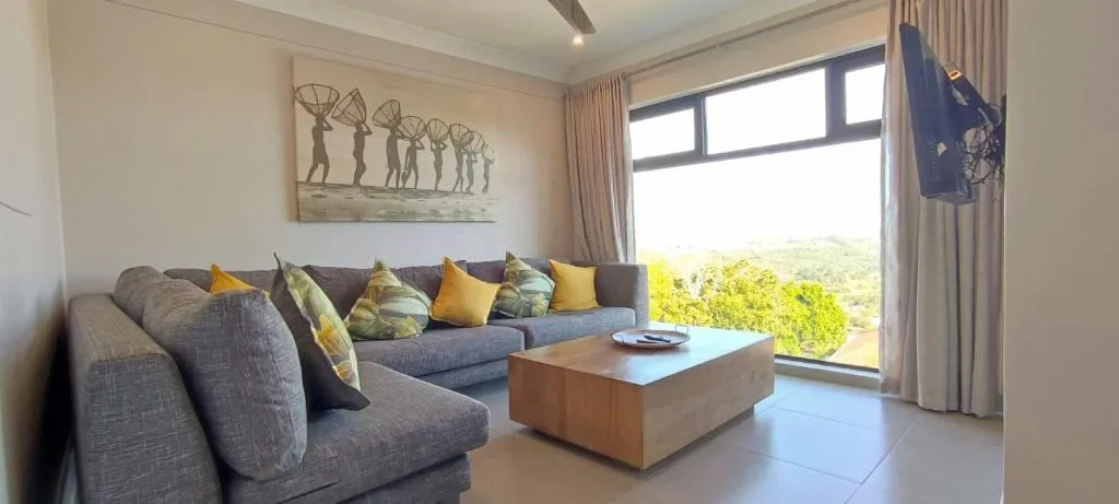 Contemporary lounge with gray sectional sofa and scenic garden view through large windows