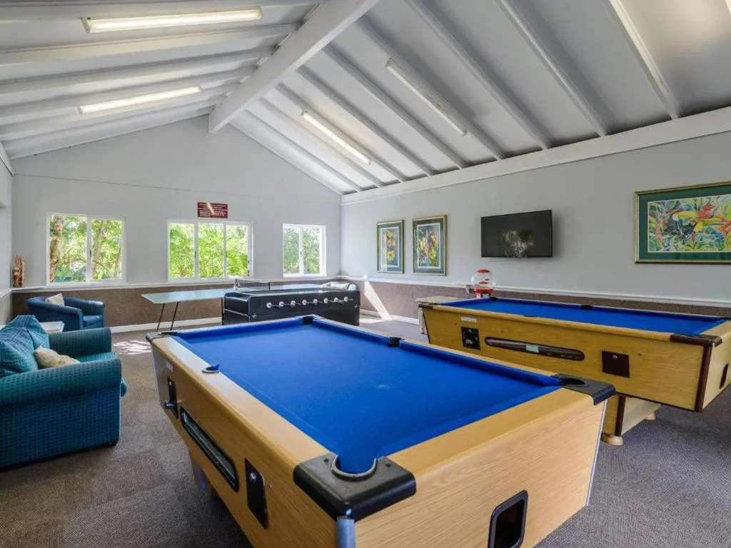 Spacious games room with pool tables, foosball, and comfortable seating areas