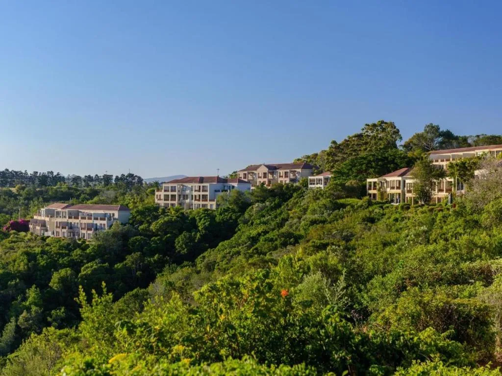Residential properties nestled among lush green vegetation on hillside
