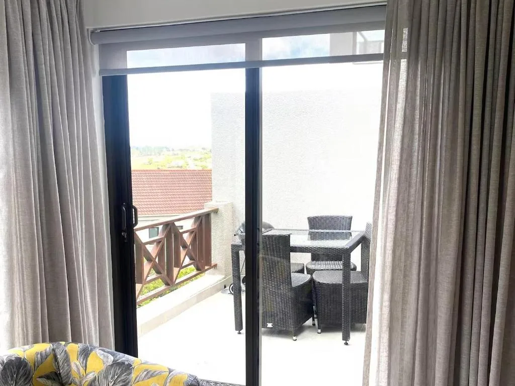 Outdoor patio with rattan furniture and scenic countryside views beyond