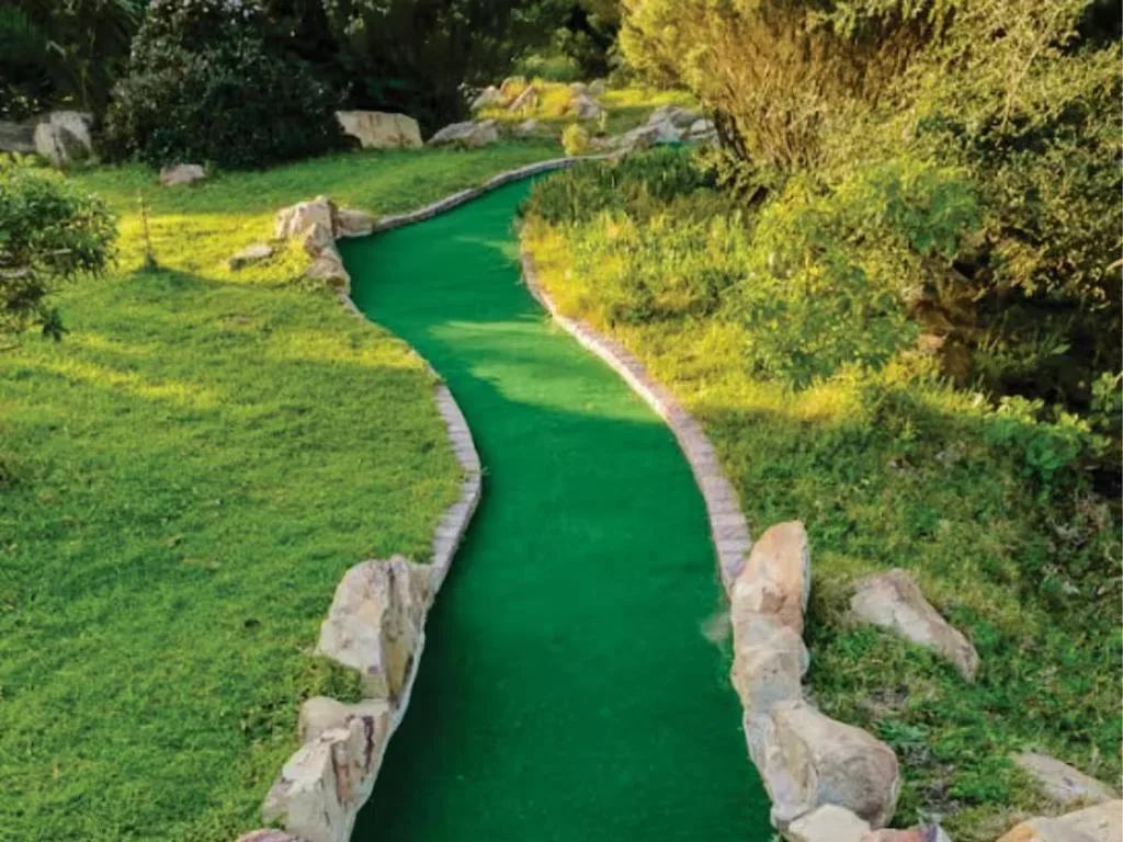 Miniature golf course green fairway with landscaped garden surroundings