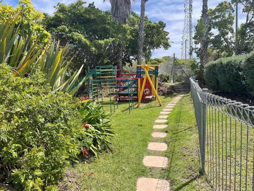 Spacious garden with children's play equipment and stepping stone pathway