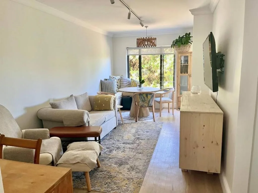 Bright modern lounge with cream sofa, wooden furniture, and garden views