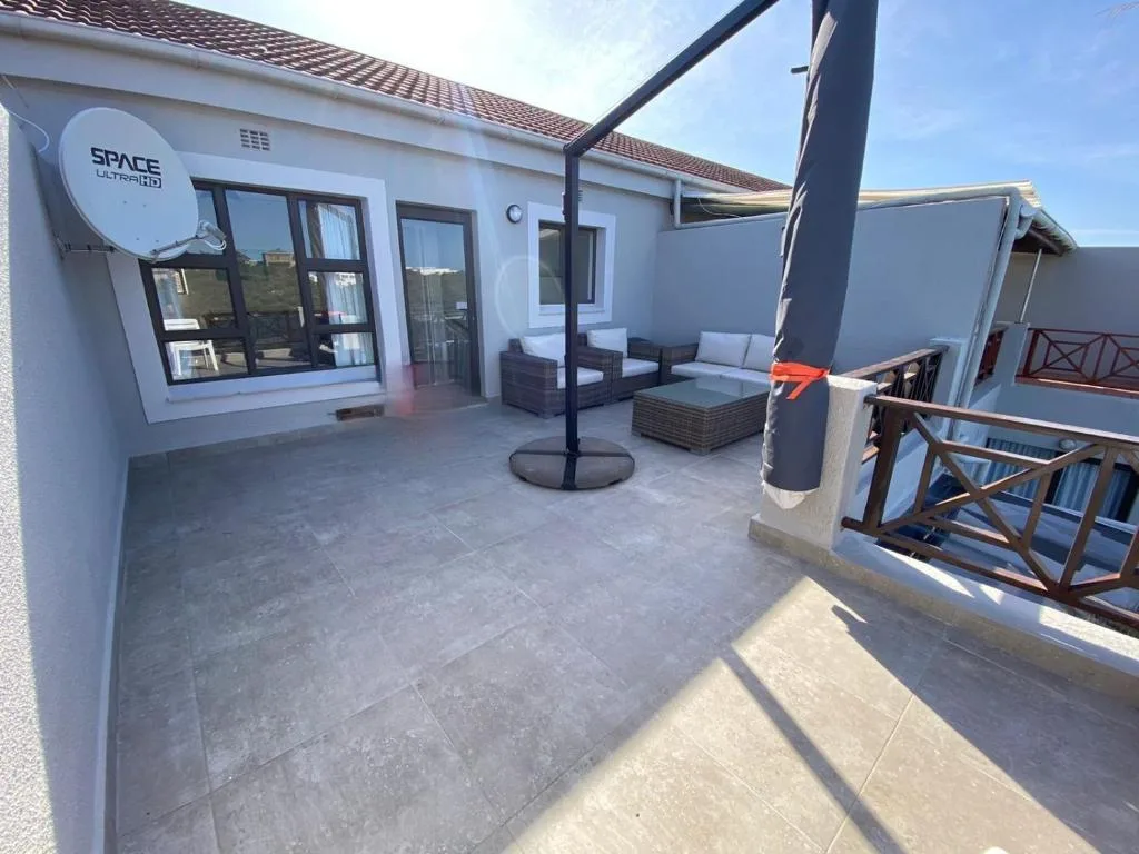 Spacious patio with outdoor seating, umbrella, and mountain views