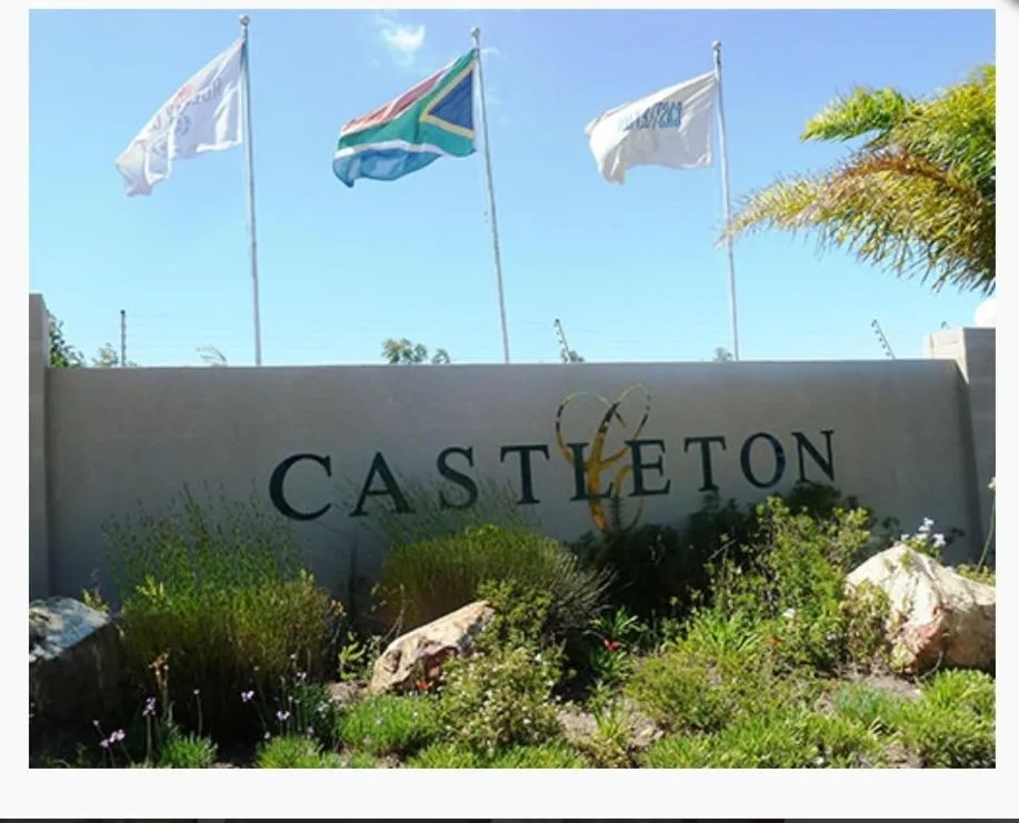 Castleton property entrance sign with flags and native landscaping