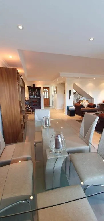 Open-plan living area with dining table, seating, and staircase visible