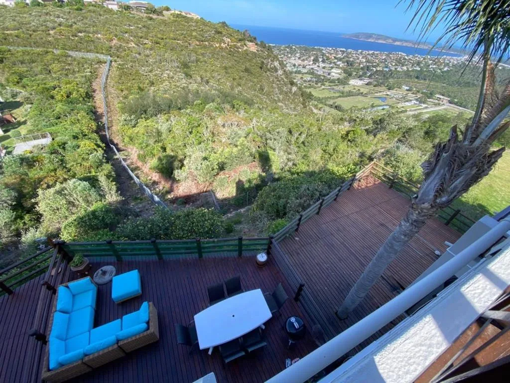 Expansive coastal valley and ocean views from elevated deck with furniture