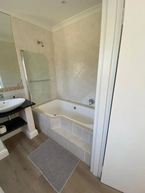 Modern bathroom with bathtub, shower enclosure, and vanity sink