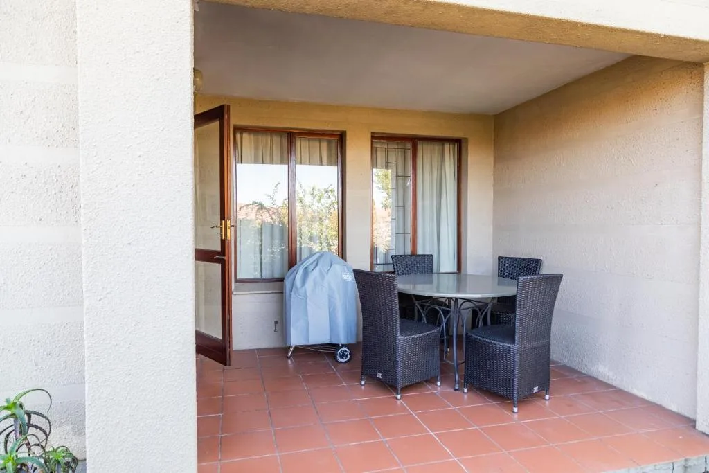 Covered patio with rattan dining furniture and ocean views