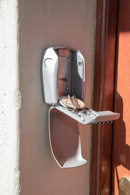 Wall-mounted automatic hand sanitizer dispenser near wooden door frame