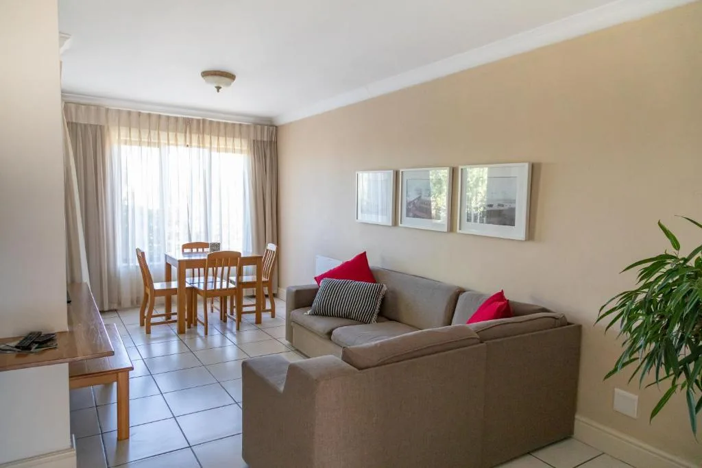 Spacious lounge with gray sofa, dining table, and garden views